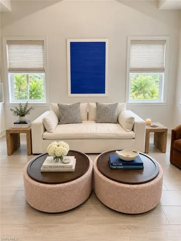 Vaulted ceiling, recessed lighting, tile flooring, window treatments, and white wall finishes