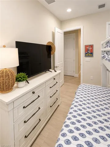 Recessed lighting, light wood-finish flooring, white paneled door, and bunk bed frame