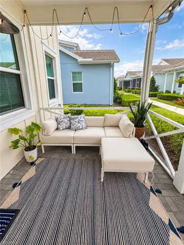 Covered patio featuring string lighting, a screened enclosure, and paver flooring
