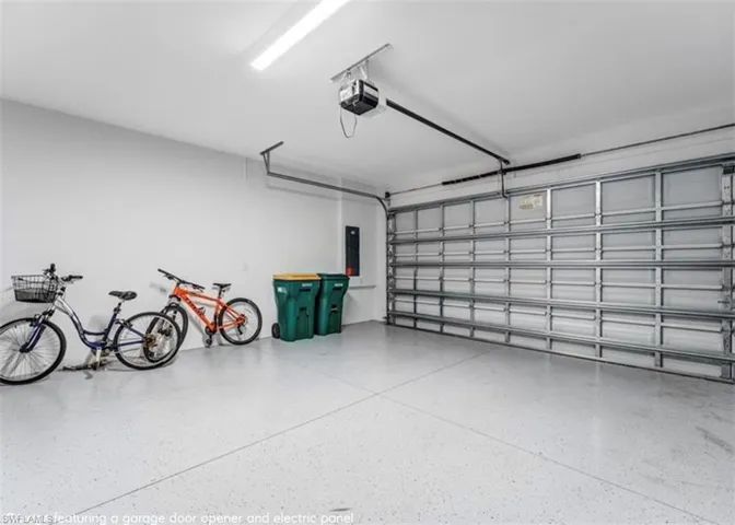 Garage featuring a garage door opener and electric panel