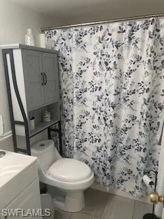 Full bathroom with vanity, a shower with shower curtain, and tile patterned floors