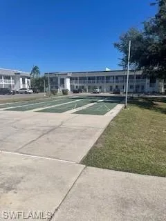 View of property's community featuring shuffleboard and a yard