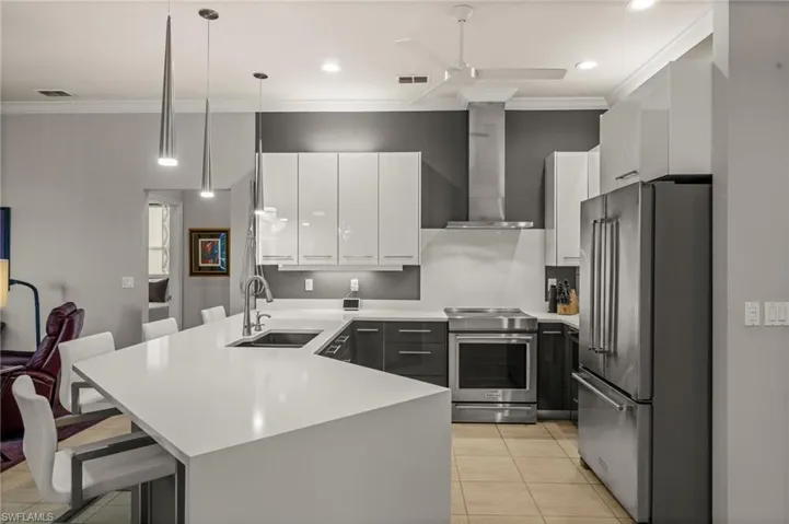 Kitchen featuring a breakfast bar area, white cabinets, appliances