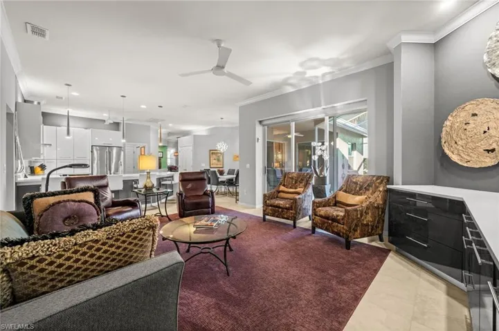 Living room with ornamental molding, a ceiling fan, recessed lighting
