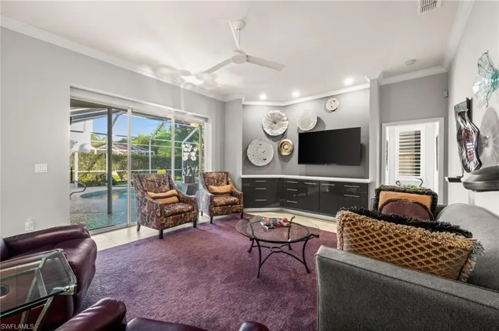 Living area featuring ceiling fan, crown molding, plenty of natural light
