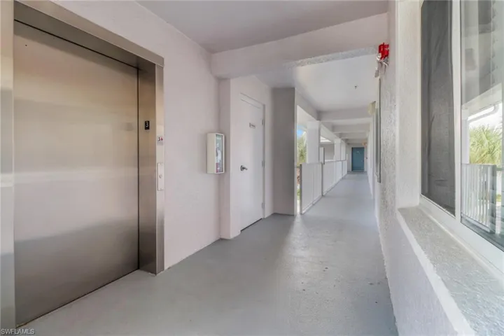 Hall featuring elevator, healthy amount of natural light, and finished concrete floors
