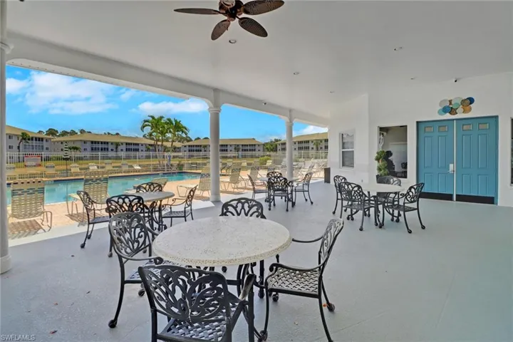 View of patio with a ceiling fan and a community pool