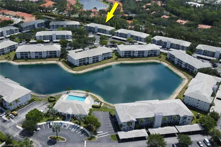 Bird's eye view of a large body of water, a pool area, and apartment complex