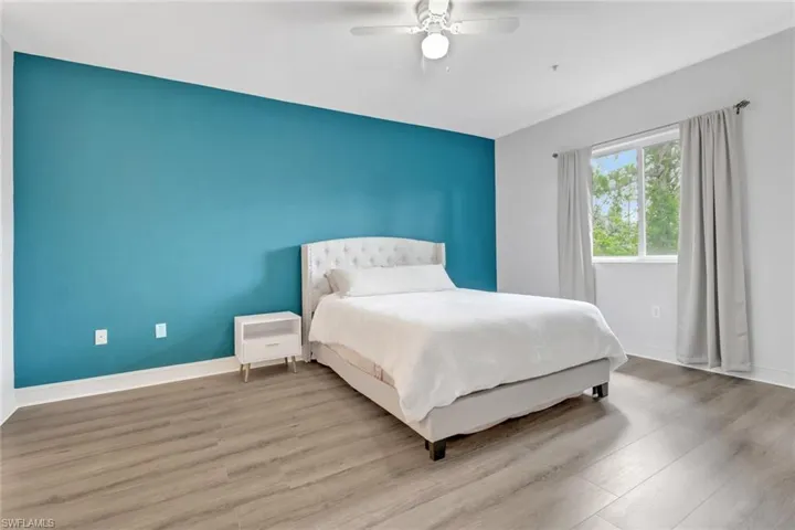 Bedroom featuring wood finished floors, baseboards, and ceiling fan
