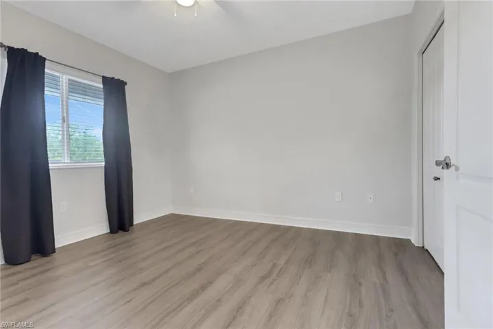 Unfurnished room featuring light wood-style flooring, a ceiling fan, and baseboards