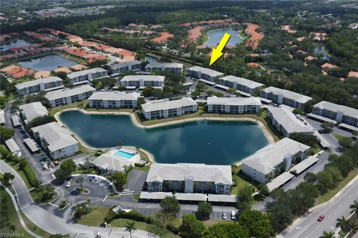 Aerial view of property and surrounding area featuring a large body of water and nearby suburban area