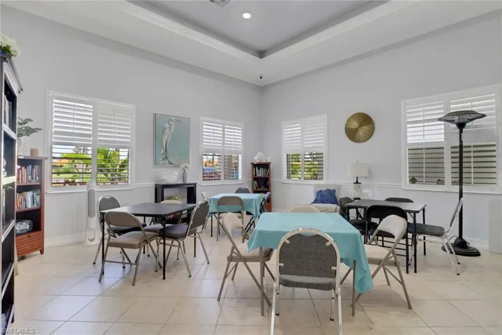 Dining space with light tile patterned floors, ornamental molding, and baseboards