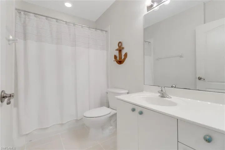 Full bathroom featuring vanity, toilet, tile patterned flooring, and shower / bath combination with curtain