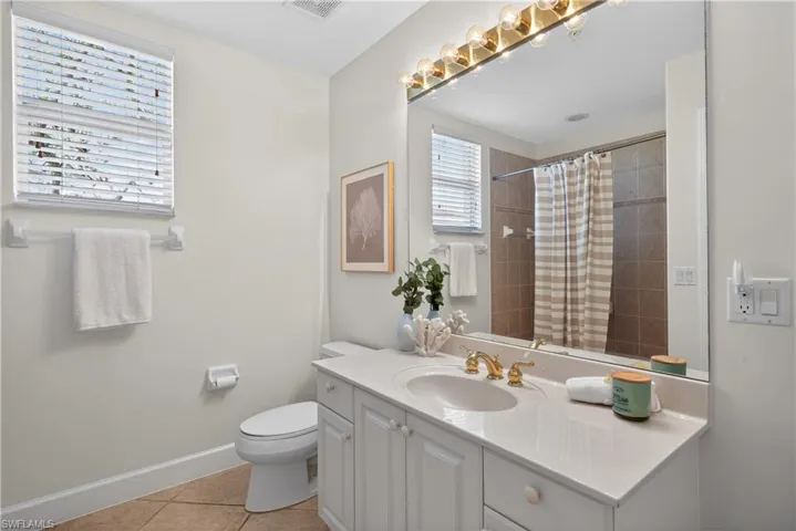 Bathroom with vanity, a shower with shower curtain, and light tile patterned flooring