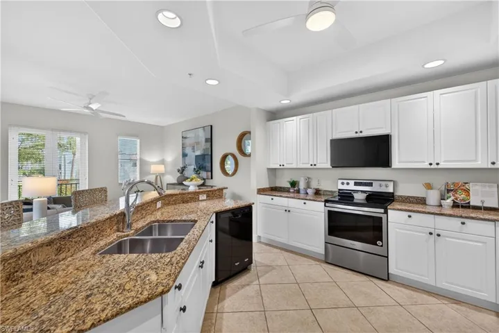 Kitchen with ceiling fan, white cabinetry, black appliances, recessed lighting, and dark stone counters