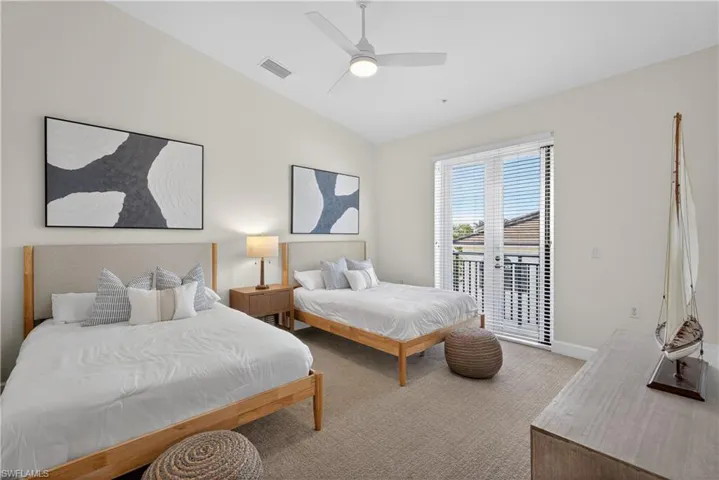 Bedroom with light colored carpet, vaulted ceiling, a ceiling fan, and access to outside