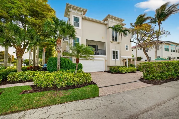 View of front of property featuring decorative driveway, stucco siding, a balcony, and a garage