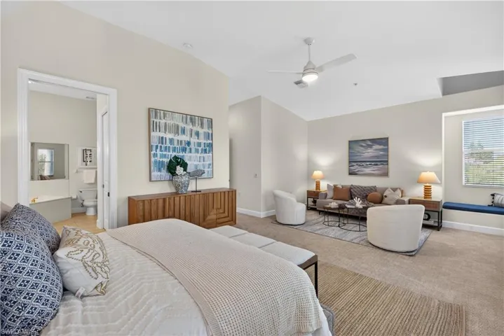 Bedroom with carpet, vaulted ceiling, a ceiling fan, and ensuite bathroom
