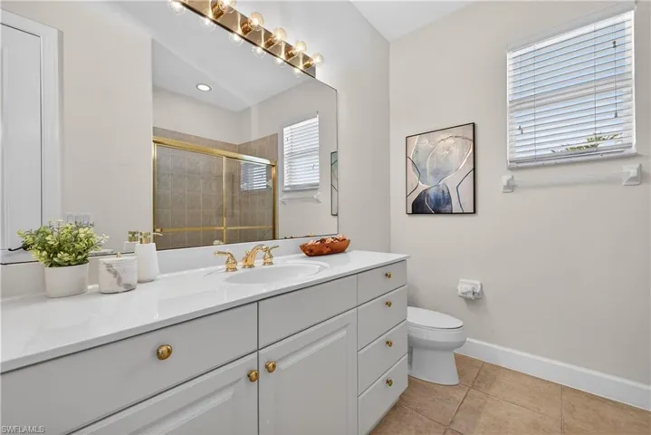 Bathroom with vanity, a shower stall, and light tile patterned floors