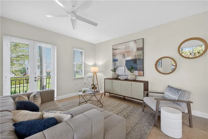 Tiled living area featuring baseboards and a ceiling fan