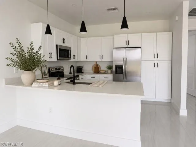 Angle 1- Modern kitchen with quartz countertops, stainless steel appliances, and ample cabinetry.