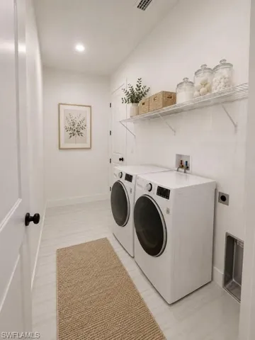 Dedicated indoor laundry room with additional storage space.