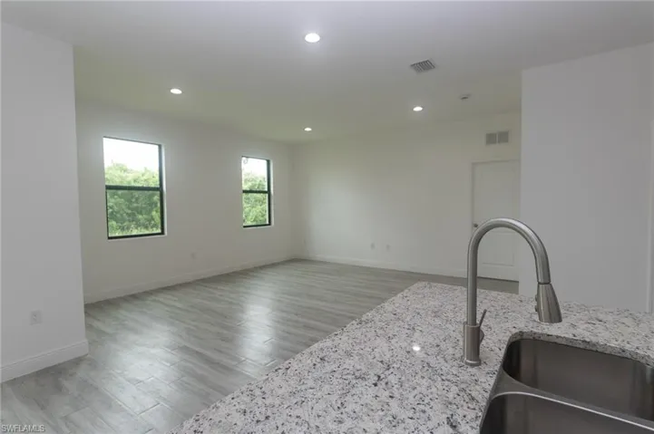 Kitchen featuring light hardwood / wood-style flooring, sink, and light stone countertops
