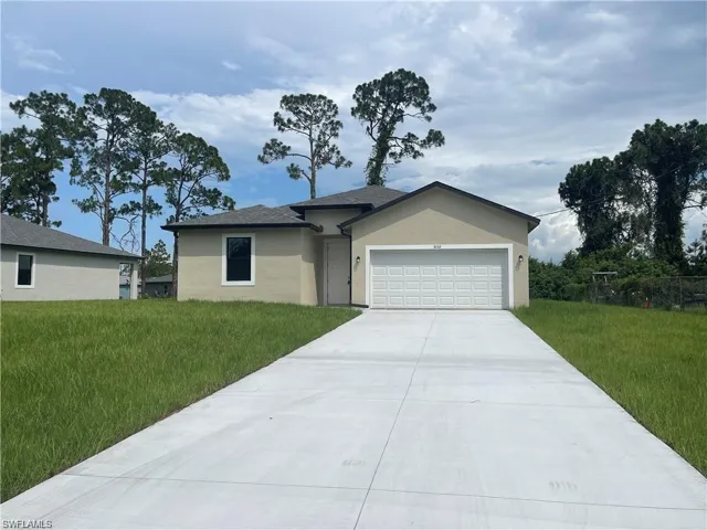 View of front facade featuring a front yard and a garage