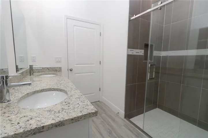 master Bathroom featuring double vanity and a shower with door