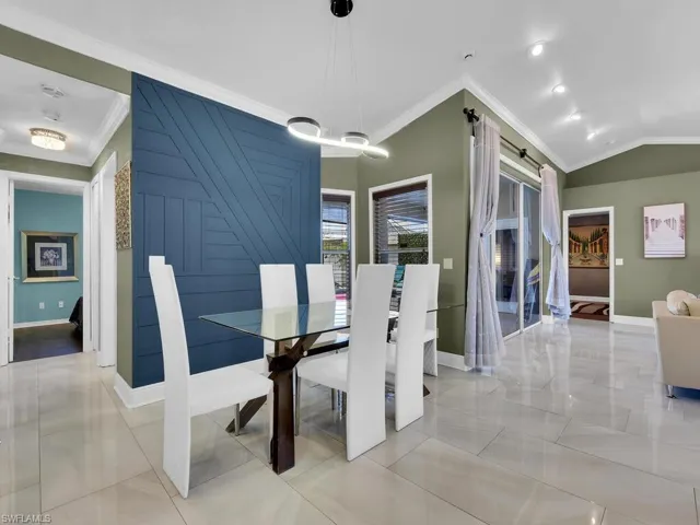 Dining room featuring lofted ceiling and ornamental molding