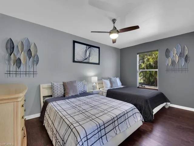 Bedroom with ceiling fan and dark hardwood / wood-style flooring