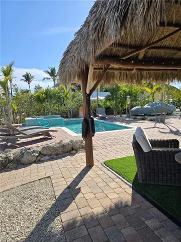 View of swimming pool with a hot tub, a gazebo, and a patio area