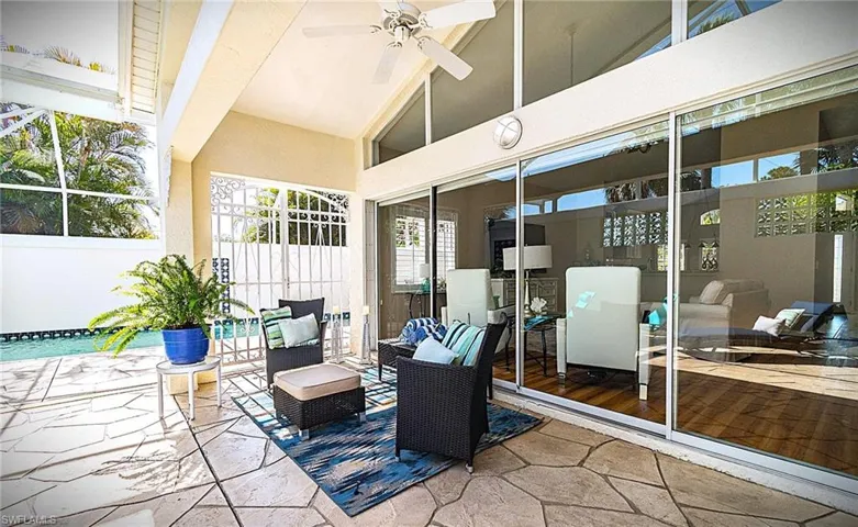 View of patio with a ceiling fan and a lanai