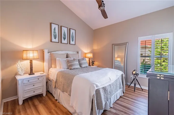 Bedroom with wood finished floors, vaulted ceiling, and ceiling fan