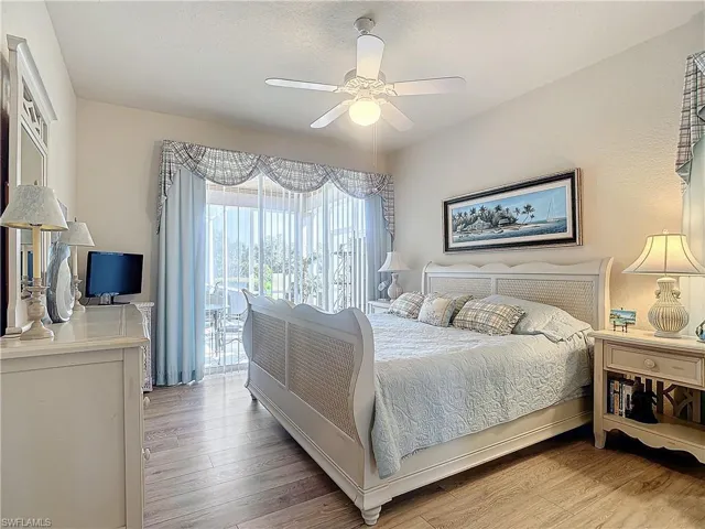 Bedroom with light wood-type flooring, ceiling fan, and access to outside