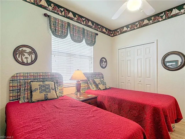 Bedroom with a closet, ceiling fan, and wood-type flooring
