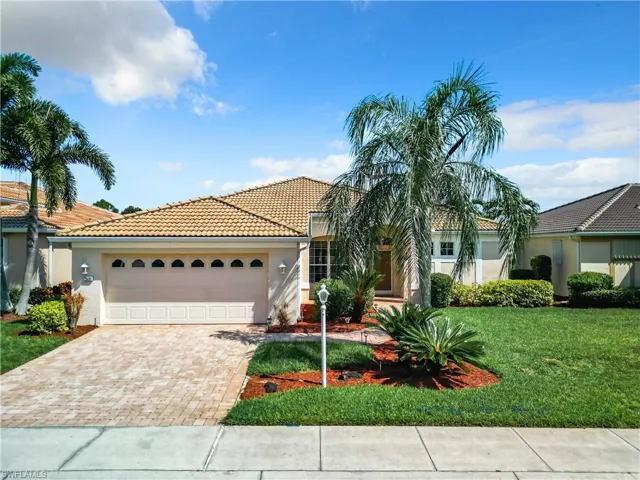 Mediterranean / spanish-style house featuring a garage and a front lawn