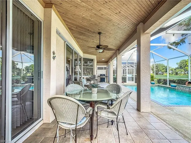 View of patio / terrace with glass enclosure, area for grilling, and ceiling fan