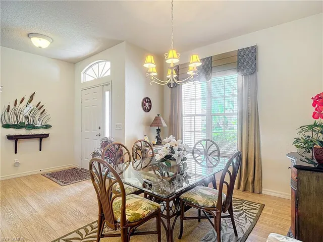 Dining room featuring an inviting chandelier, light hardwood / wood-style floors, and a textured ceiling