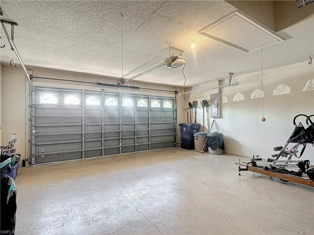 Garage featuring electric panel and a garage door opener