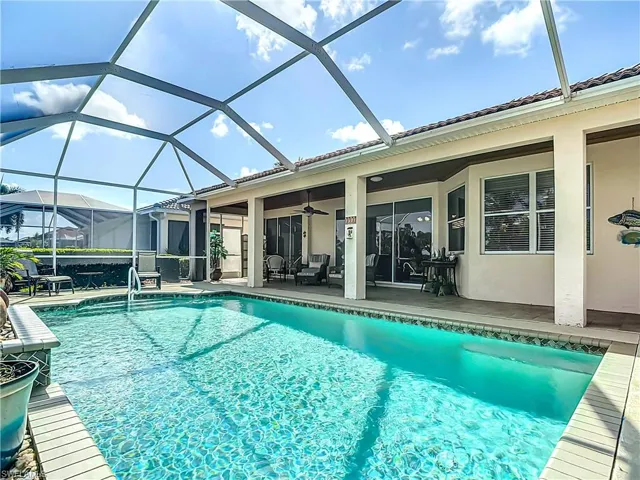 View of swimming pool featuring a patio, a lanai, and ceiling fan