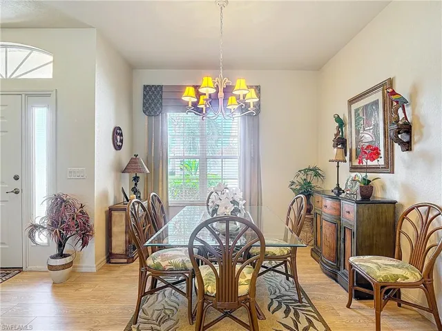 Dining area with light hardwood / wood-style flooring and an inviting chandelier