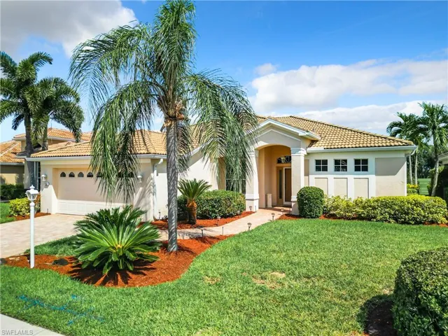 Mediterranean / spanish home featuring a front yard and a garage