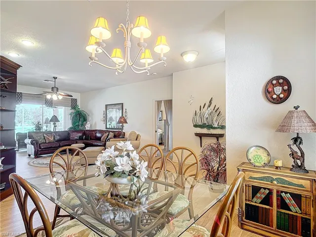 Dining room featuring light wood-type flooring and ceiling fan with notable chandelier