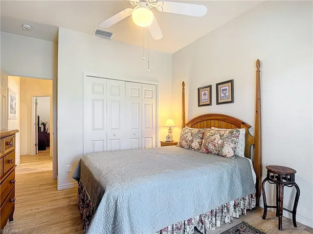 Bedroom with ceiling fan, a closet, and light hardwood / wood-style flooring