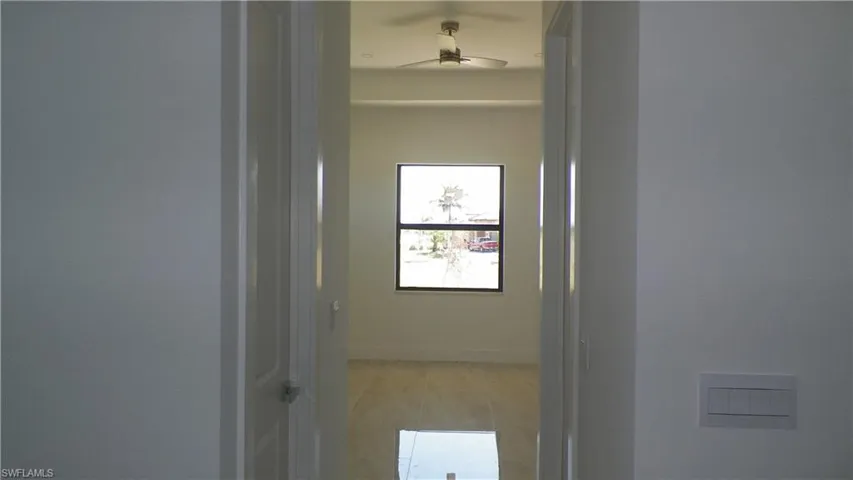 Hallway with baseboards and light tile patterned flooring