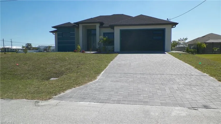 Prairie-style home with stucco siding, an attached garage, decorative driveway, and a front yard
