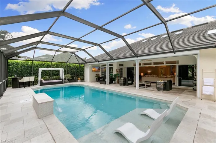 View of swimming pool featuring an outdoor living space, pool water feature, a patio, and a lanai
