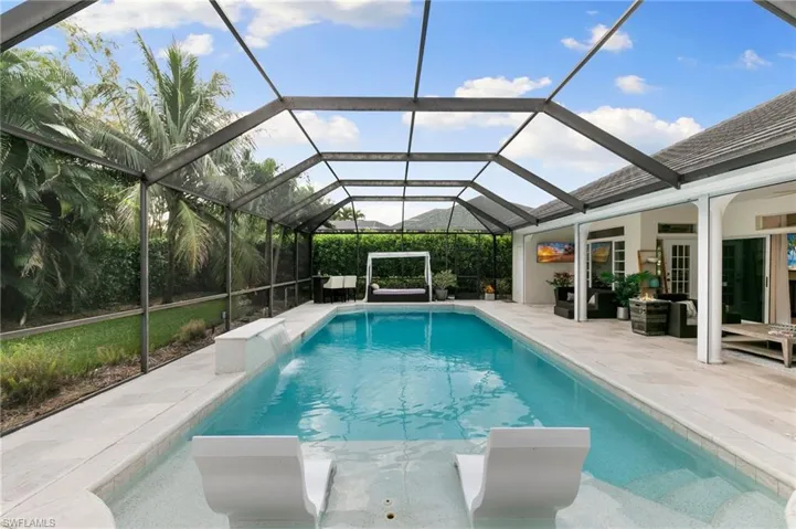 View of pool with a patio and glass enclosure