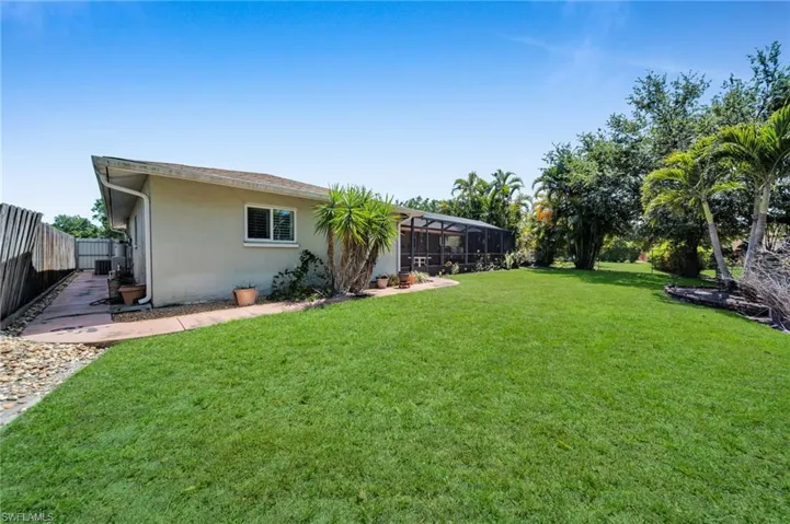 View of yard with glass enclosure and fence